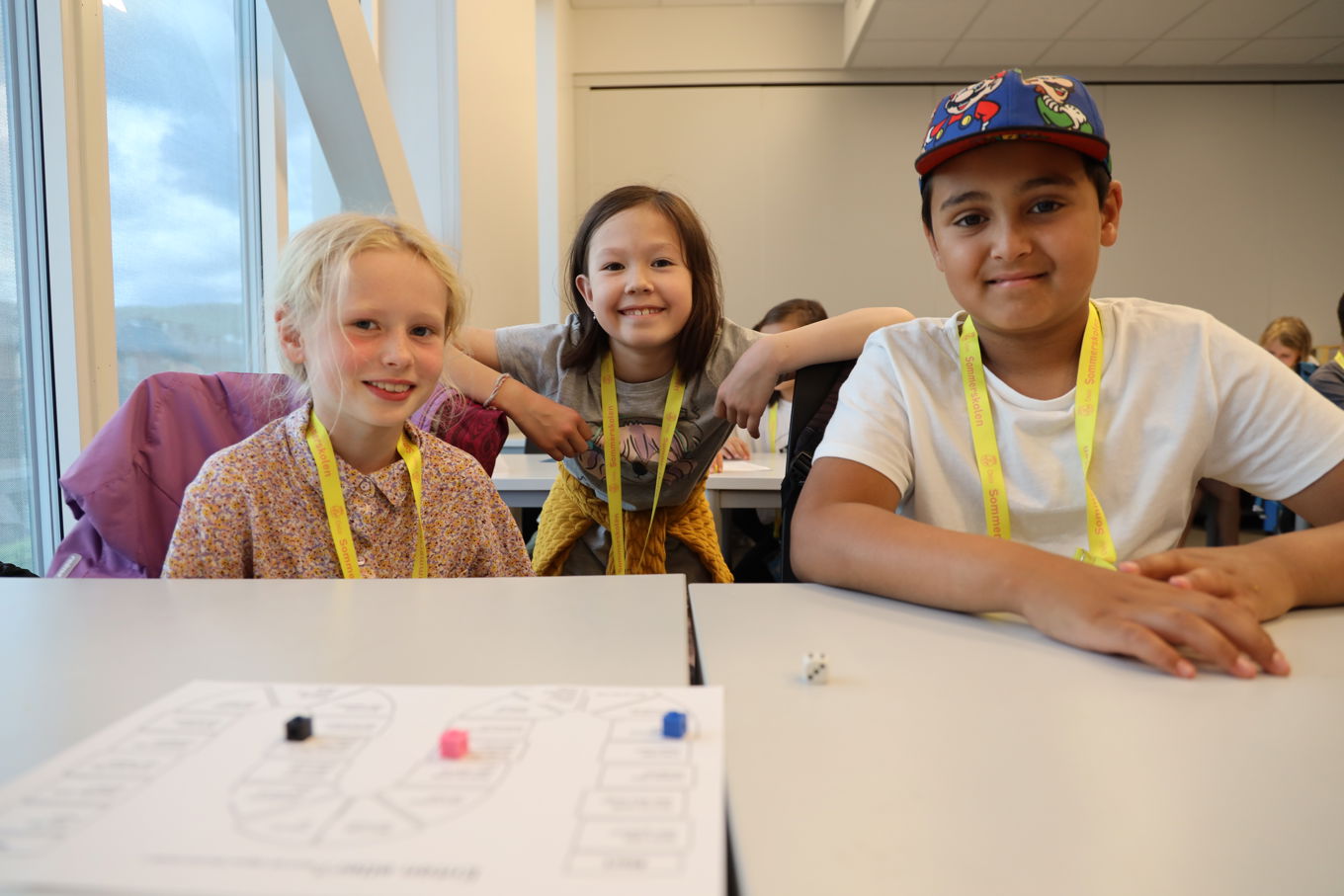 en gruppe barn som sitter ved et bord en gruppe barn som sitter ved et bord