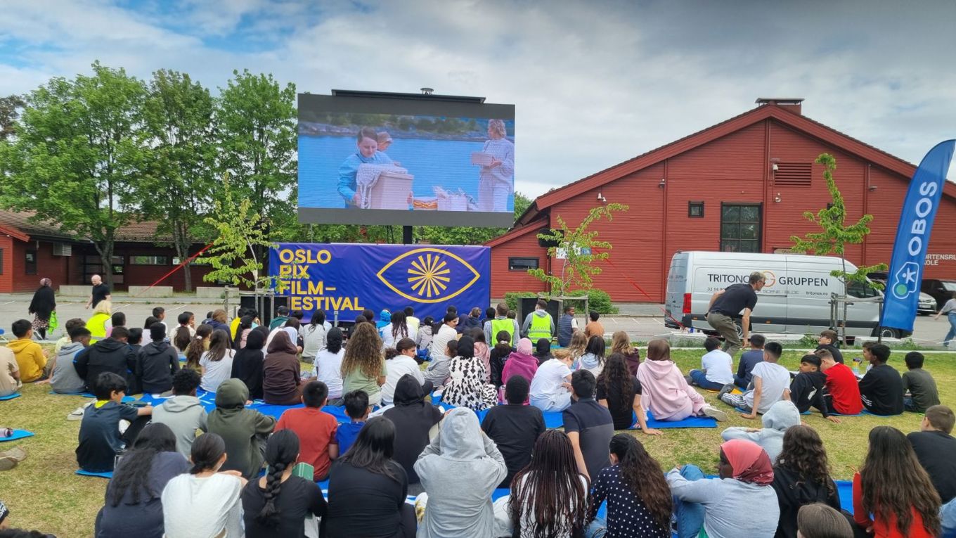 Foto: Trond Herbert Johansen en gruppe mennesker som sitter i en sirkel foran en scene