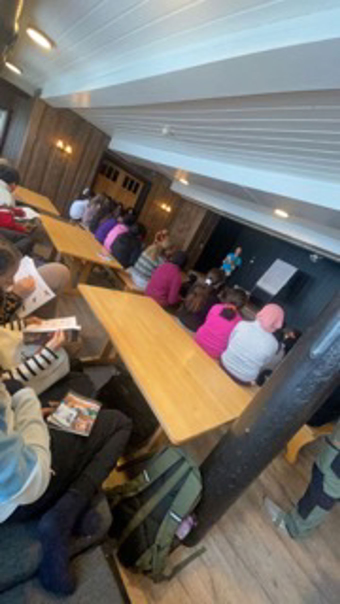 En gruppe mennesker som sitter ved et bord i et rom