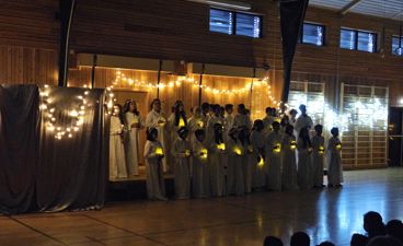 en gruppe mennesker i hvite kapper og en gruppe mennesker i et rom med en scene og