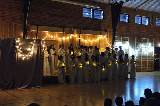 en gruppe mennesker i hvite kapper og en gruppe mennesker i et rom med en scene og