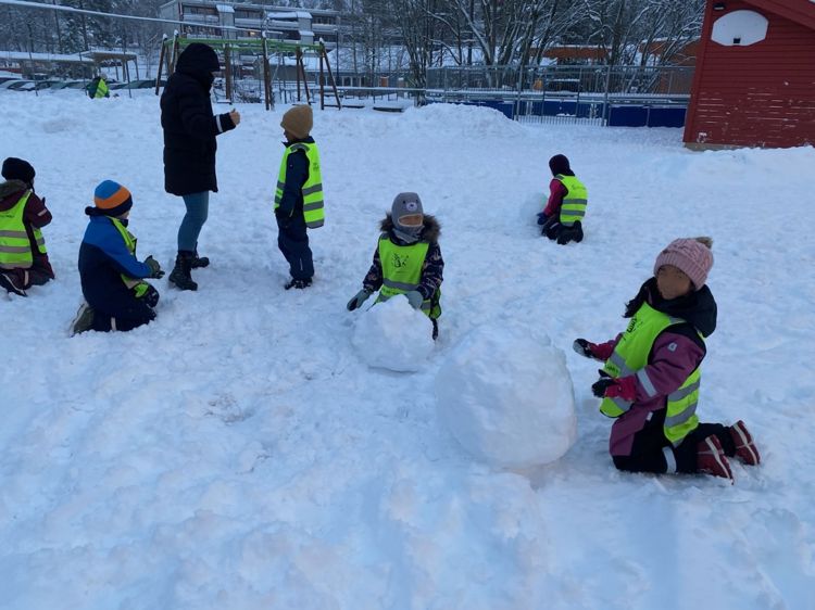 En gruppe barn som leker i snøen
