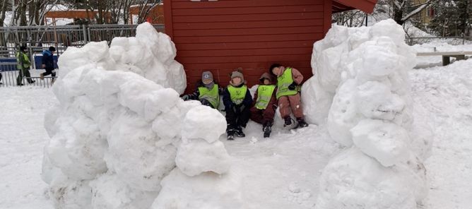 en gruppe barn som poserer med en snøperson