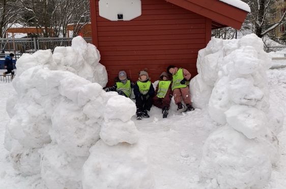 en gruppe barn som poserer med en snøperson
