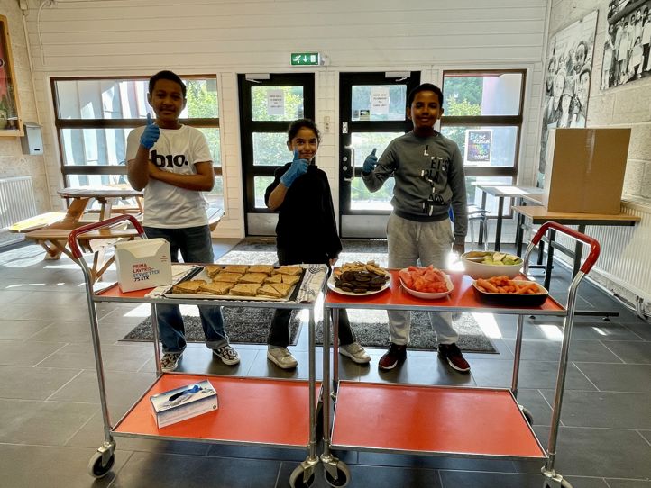 Foto: Farina Ahmed en gruppe mennesker som står ved siden av et bord med mat på