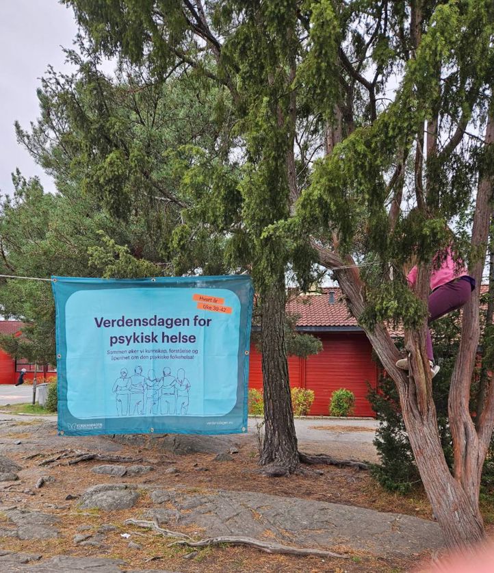 et skilt ved siden av et tre