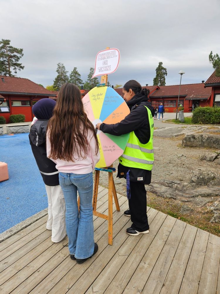 en gruppe mennesker som står på en brygge og holder et skilt
