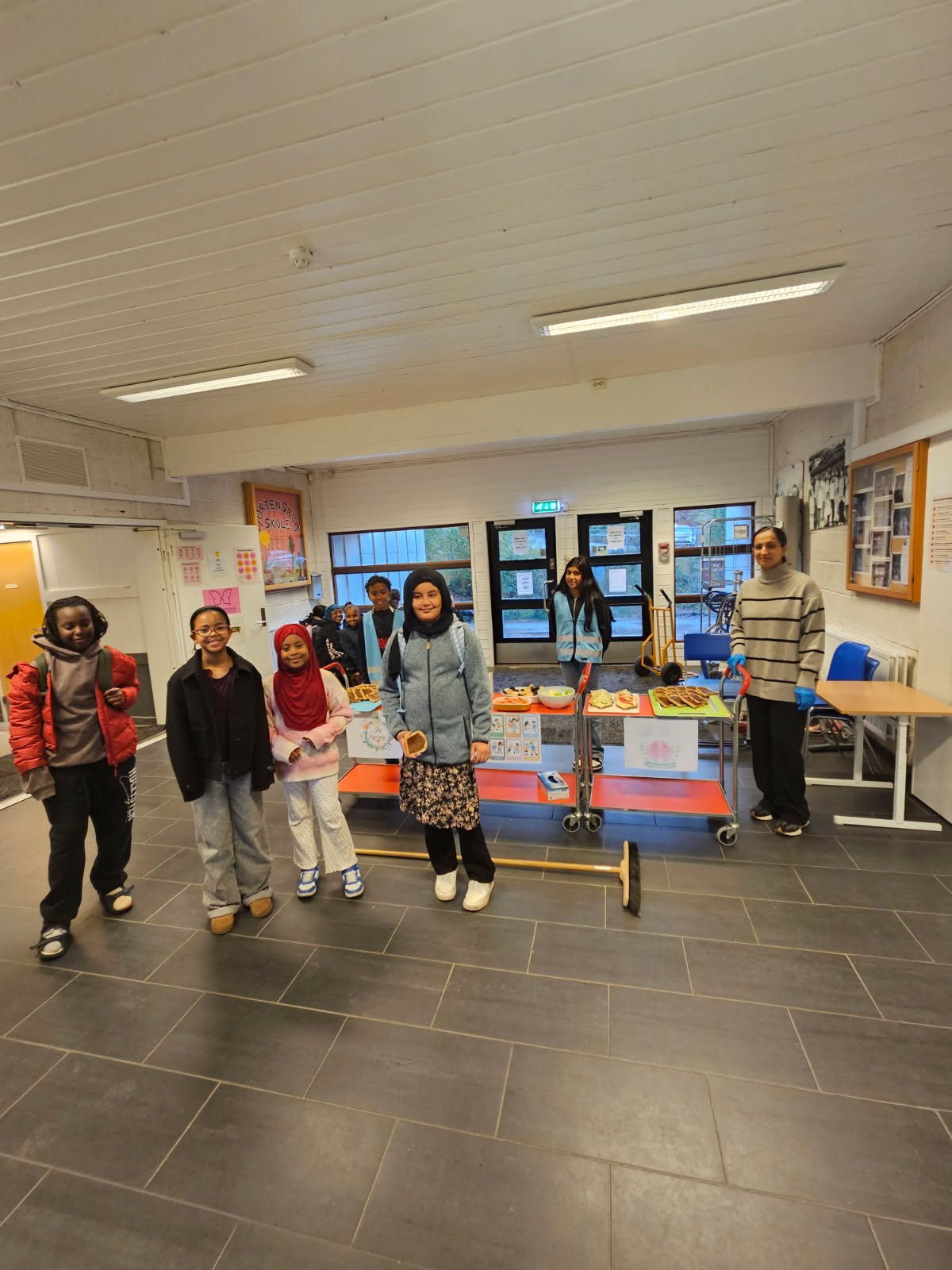 en gruppe mennesker som står i et rom med mat på fat