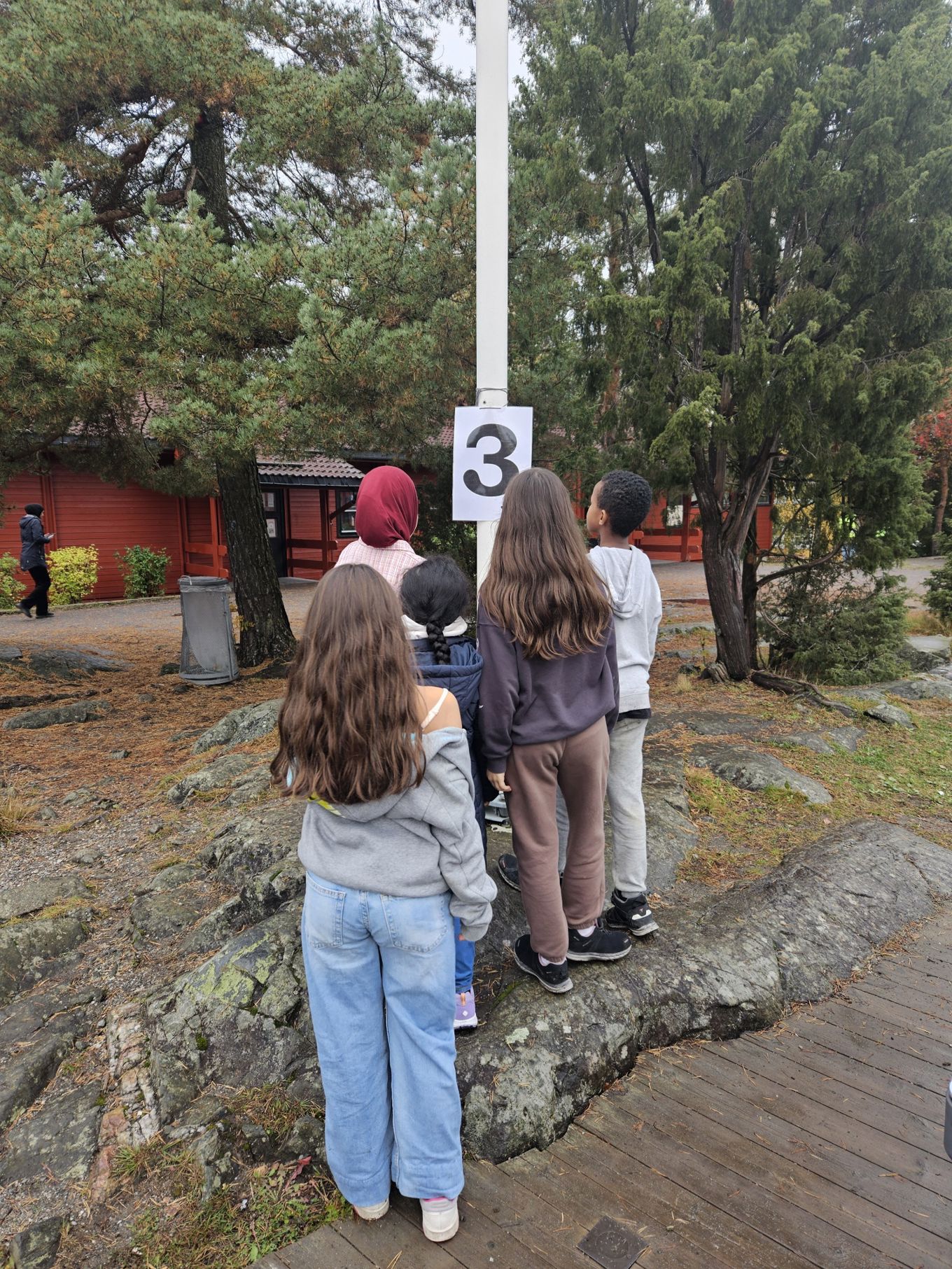 Foto: Siri Bolstad en gruppe mennesker som står på en steinsti med et skilt