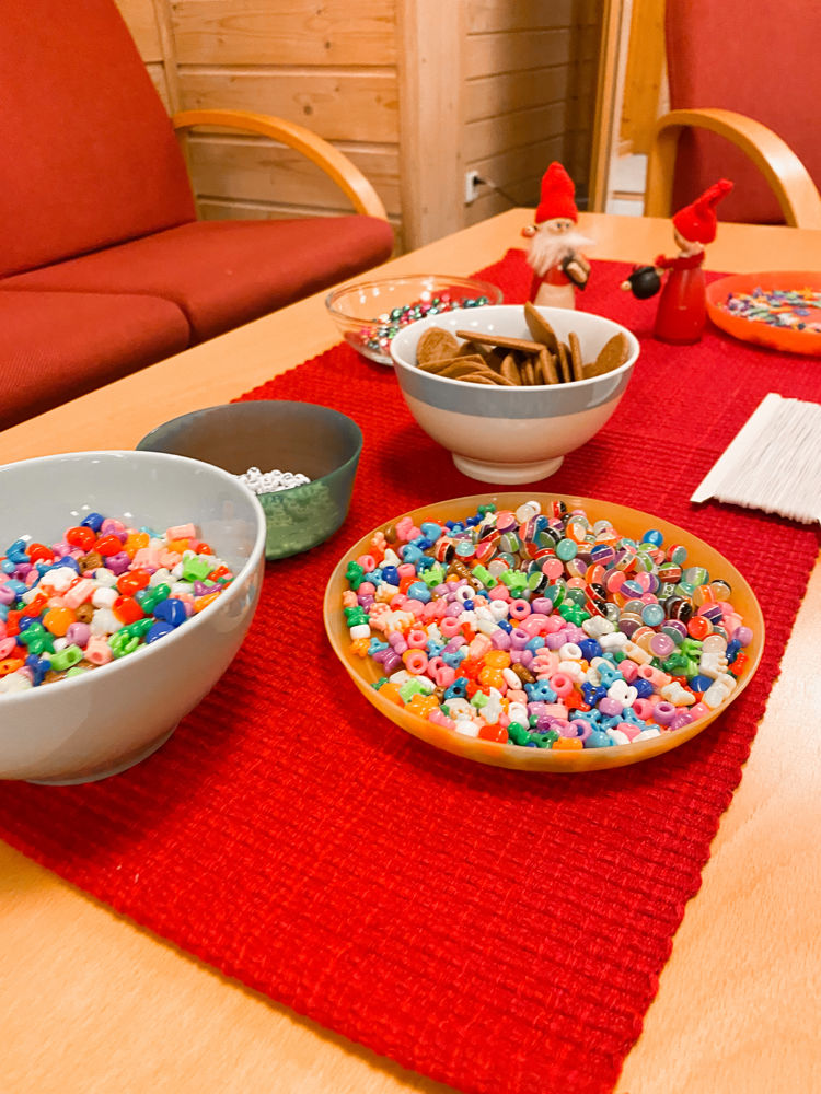 Skåler fylt med perler i alle farger og fasonger på rød brikke
